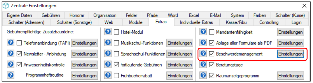 Reiter Extras der Zentralen Einstellungen mit den gebührenpflichtigen Zusatzbausteinen; der Eintrag Beschwerdemanagement mit gesetztem Häkchen und der Schaltfläche Einstellungen ist rot umrandet